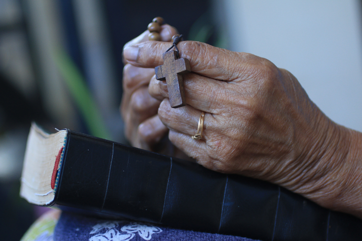 senior-hands-praying-rosary-bible