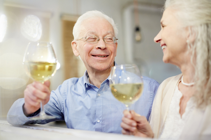senior-couple-smiling-and-holding-wine-glassses